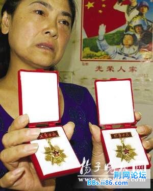 袁亚萍向记者展示儿子的奖章.jpg